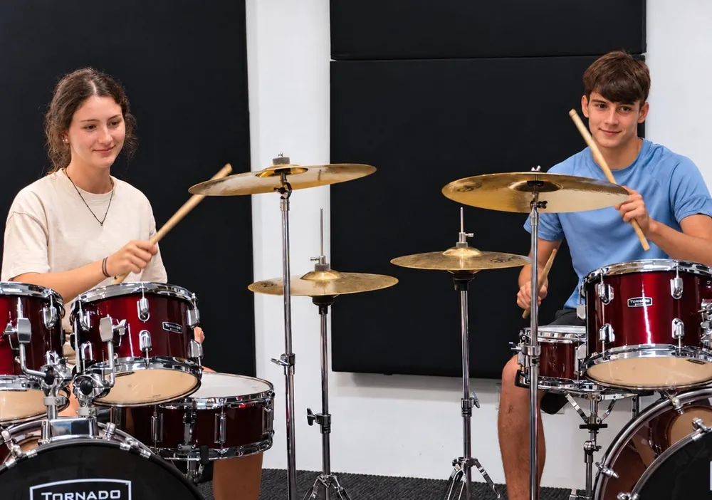 Dos alumnos tocando la batería juntos en una clase de Jambala