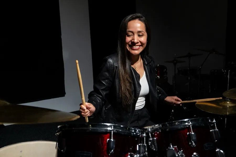 Alumna tocando la batería en la sala de Jambala